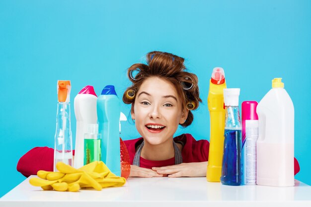 掃除用具を持つきれいな女性は笑顔で満足そうに見える