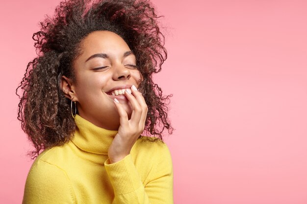 Pretty woman with curly hair and yellow turtleneck