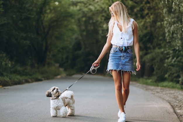 Free photo pretty woman with her dog out in the park