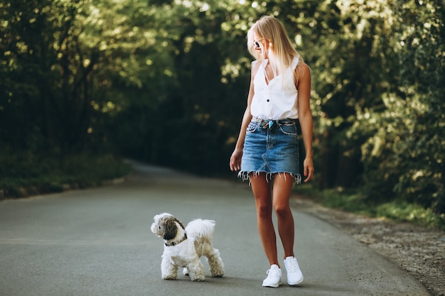 Pretty woman with her dog out in the park