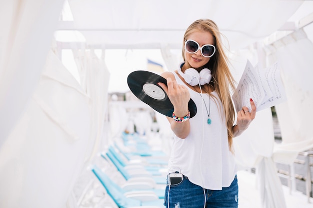 Pretty woman with papers and vinyl records