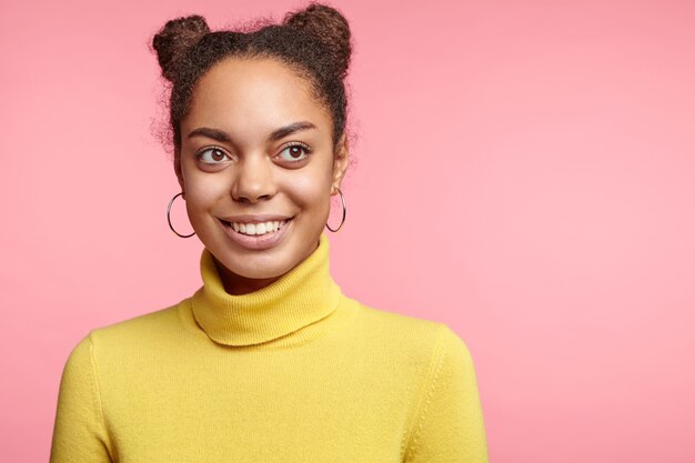 Pretty woman with space buns and yellow turtleneck
