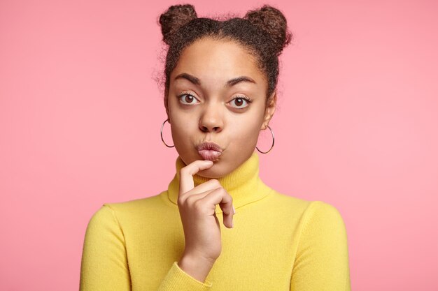 Pretty woman with space buns and yellow turtleneck