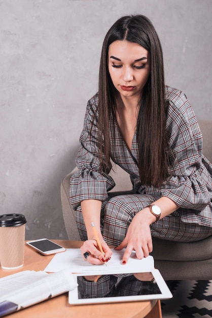 Donna graziosa che scrive su carta