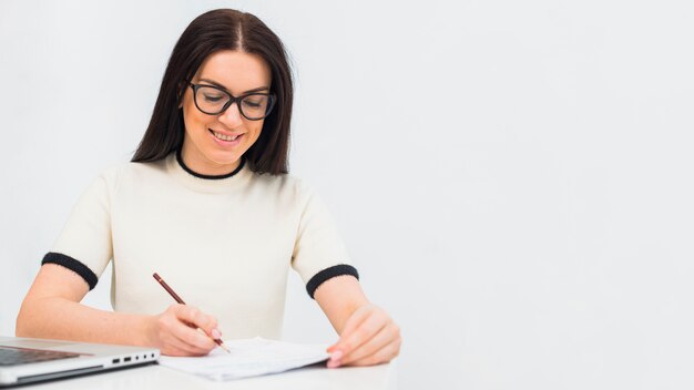 Pretty woman writing something on paper