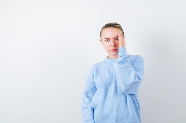 Pretty women shows her forehead pain on white background