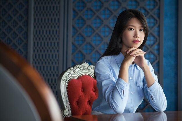 Pretty Young Asian Woman with Hands under Chin