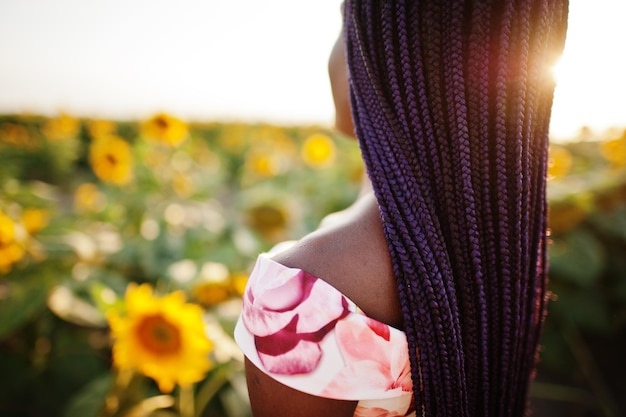 Free photo pretty young black woman wear summer dress pose in a sunflower field