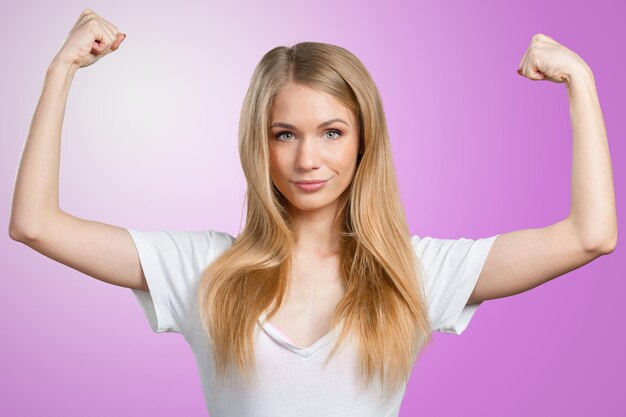 Pretty young blonde woman throwing her arms up into the air in jubilation of her success