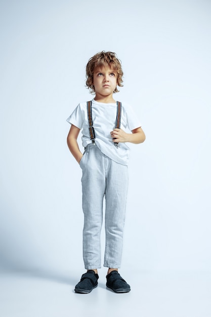 Pretty young boy in casual clothes on white studio