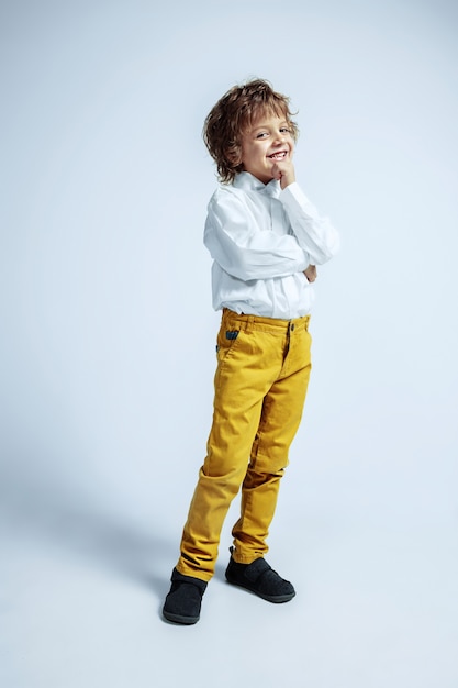 Pretty young boy in casual clothes on white