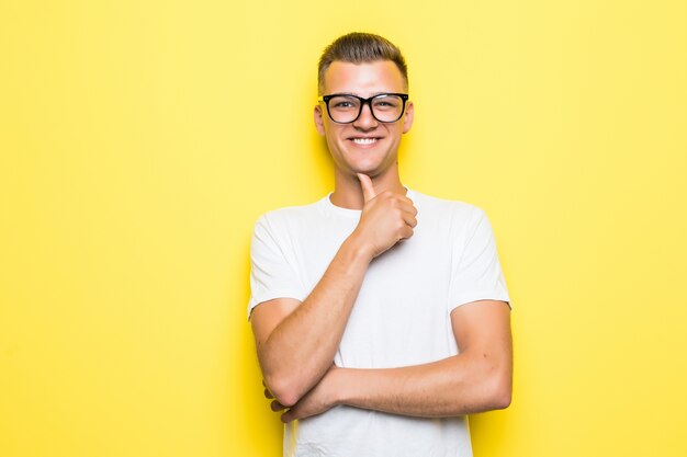 Pretty young boy hold his hand under his chin dressed up in white t-shirt and transperent glasses