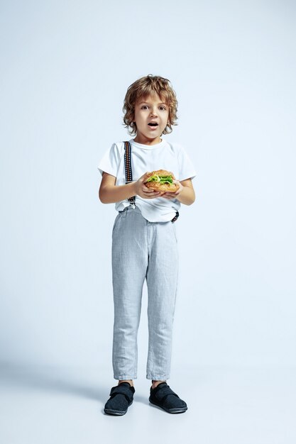 Pretty young curly boy in casual clothes on white