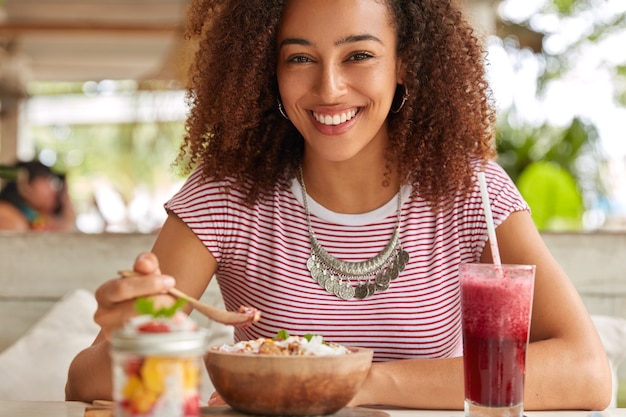 Free photo pretty young female model holds wooden spoon