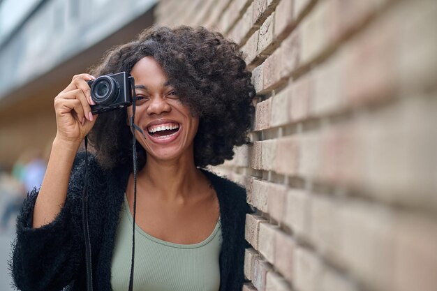 Free photo pretty young female photographer smiling positively