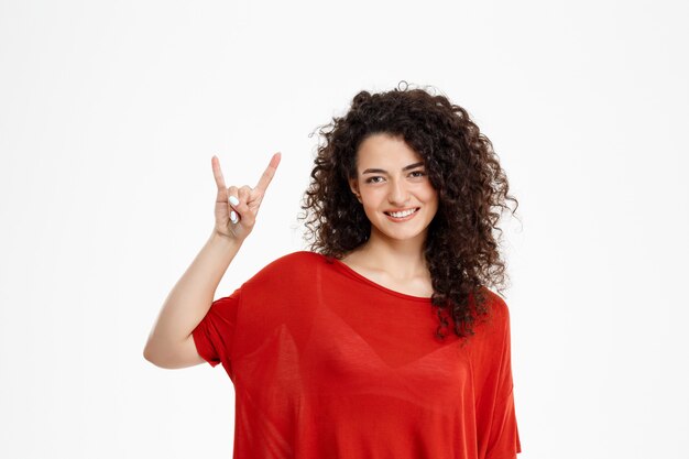 Pretty young girl doing rock gesture