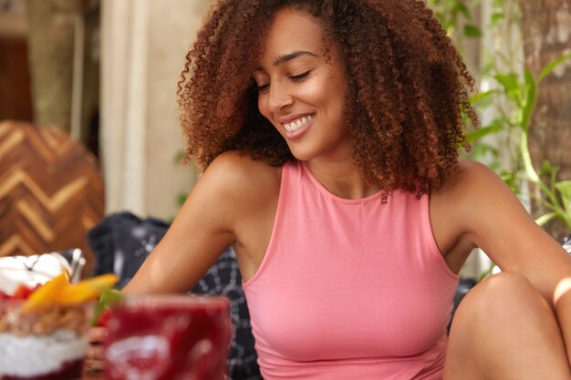 La ragazza graziosa ha un taglio di capelli afro folto