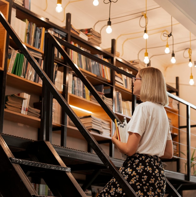 Foto gratuita ragazza graziosa in biblioteca