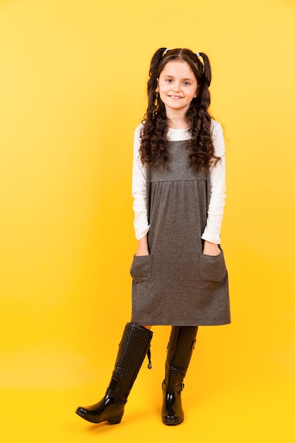 Pretty young girl posing with yellow background