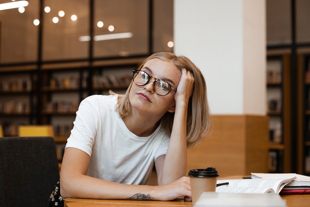 Pretty young girl thinking at the library