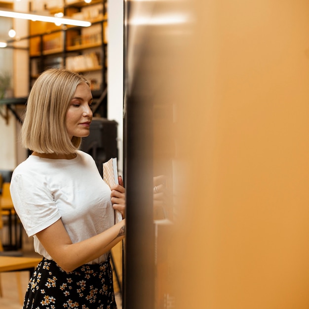 Foto gratuita ragazza graziosa che pensa alla biblioteca