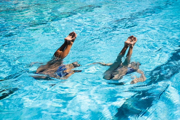 Foto gratuita ragazze abbastanza giovani che godono del tempo in piscina