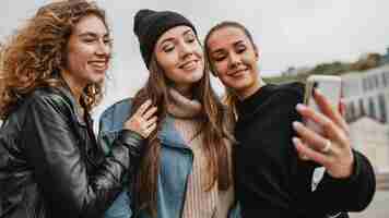 Free photo pretty young girls taking a selfie together