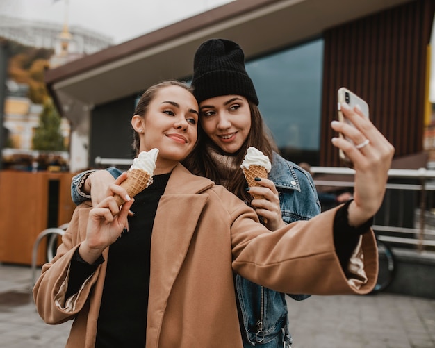 Foto gratuita belle ragazze giovani che prendono un selfie insieme