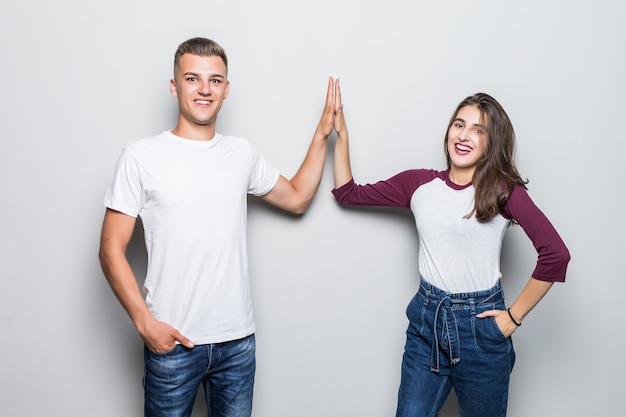 Pretty young handsome couple boy and girl give five isolated on white