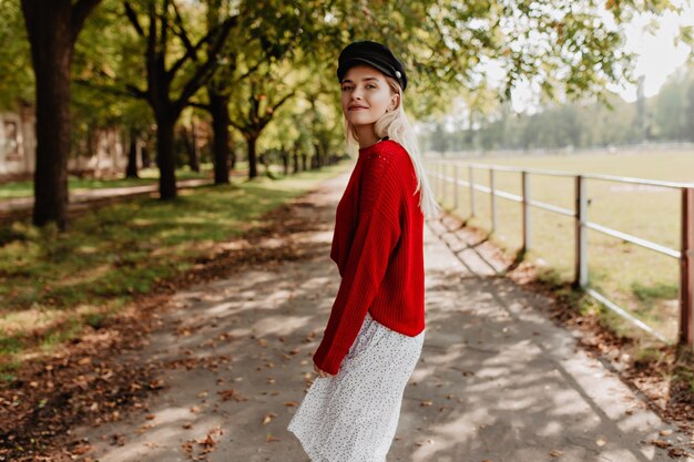 秋の公園でカジュアルな流行の服を着ているかなり若い女性。田舎でかわいく見える素敵なブロンド。