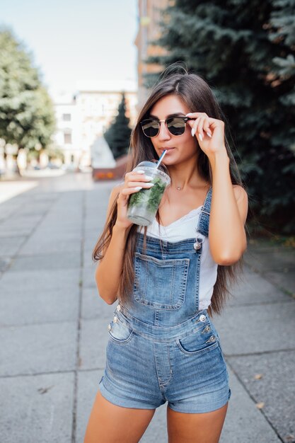 Pretty young model woman in sunglasses and shirt in the city