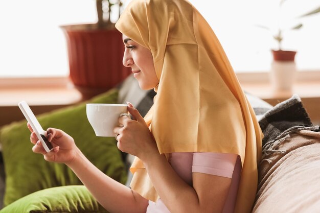 검역과 자가 격리 기간 동안 집에 있는 예쁜 젊은 이슬람 여성