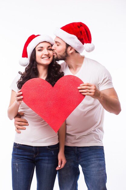 Довольно молодой Санта пара друзей мужчина женщина Рождество шляпа держать большое пустое пустое сердце, изолированные на белом фоне студии. С новым годом празднование веселого праздника концепции