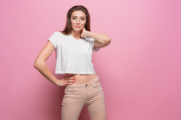 Pretty young sexy fashion sensual woman posing on pink background dressed in hipster style jeans