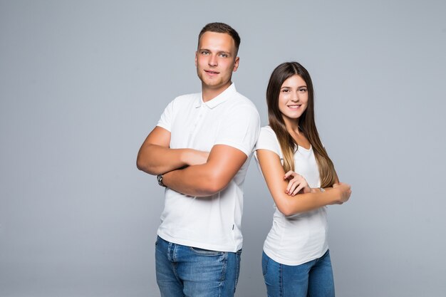 Pretty young smiling couple students studio isolated white tshirts jeans cuddles