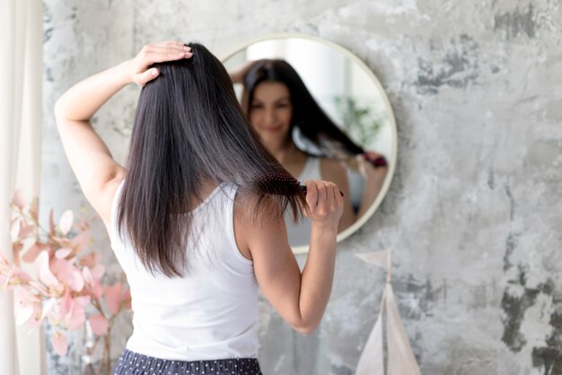 Pretty young woman brushing her hair