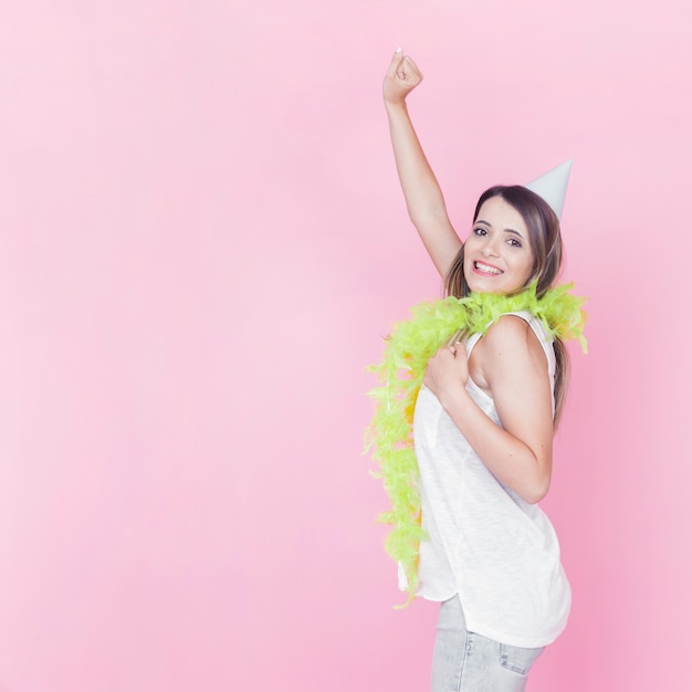 Pretty young woman dancing on pink backdrop