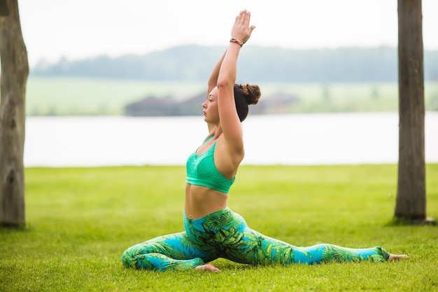 Donna abbastanza giovane che fa esercizi di yoga nel parco