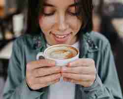 Free photo pretty young woman enjoying a coffee cup