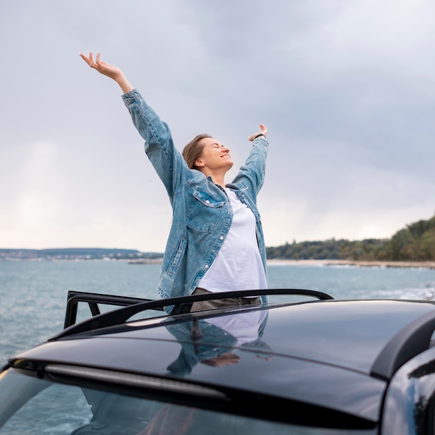 Foto gratuita donna abbastanza giovane che gode del viaggio su strada