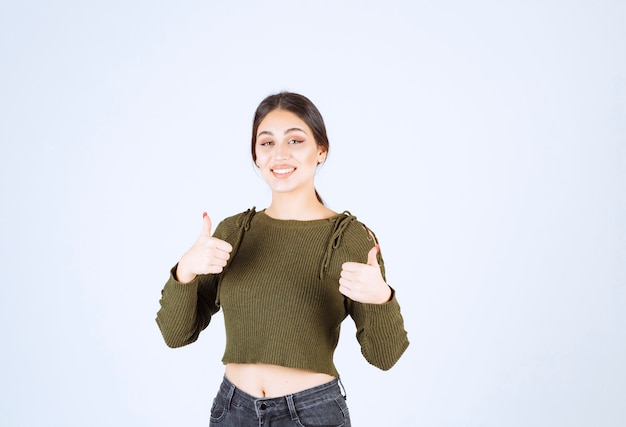 Pretty young woman giving thumbs up on white background