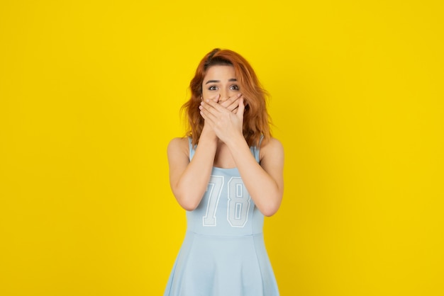 Pretty young woman holding her hands to her mouth