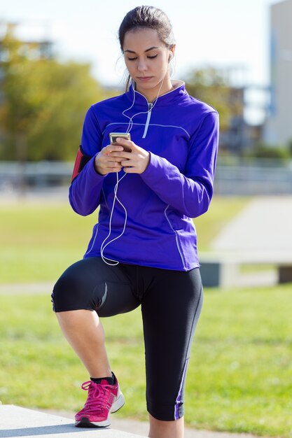 Pretty young woman listening to music after running.