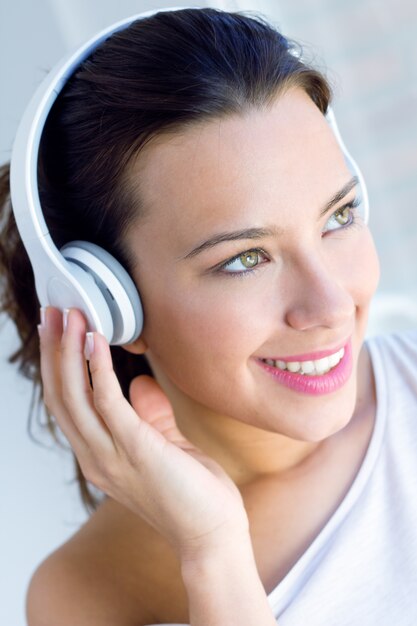 pretty young woman listening music at home