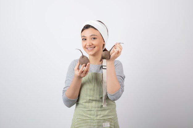 pretty young woman model in apron holding beetroots .