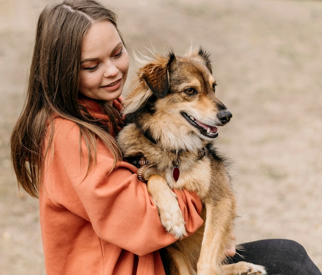 Free photo pretty young woman petting her dog