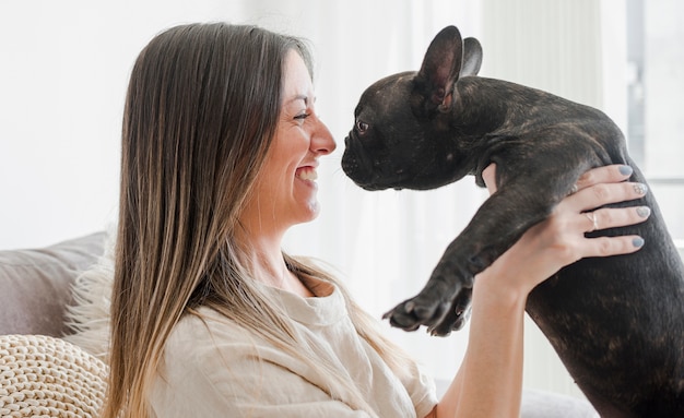 Pretty young woman playing with her puppy