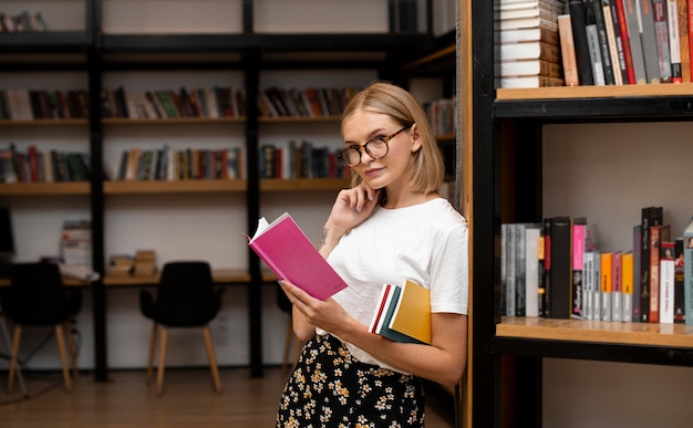 Foto gratuita bella giovane donna in posa in biblioteca