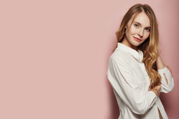 Pretty young woman posing on pink background