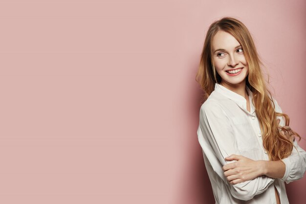 Pretty young woman posing on pink background